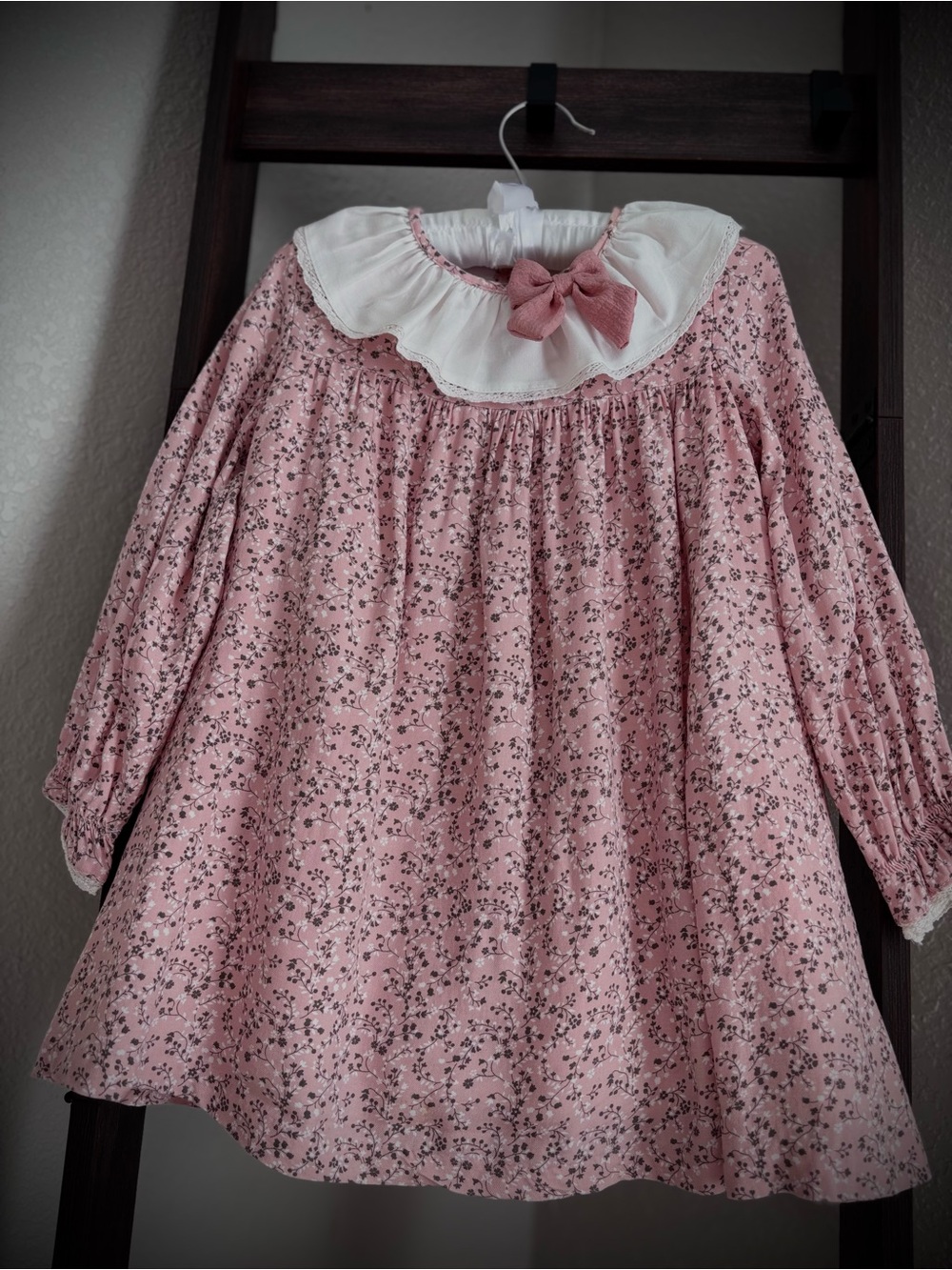 Pink floral-print dress for girls, featuring a ruffled collar and a bow, by the